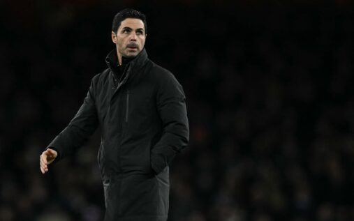 Alan Shearer speaking as a pundit with a blurred football stadium background