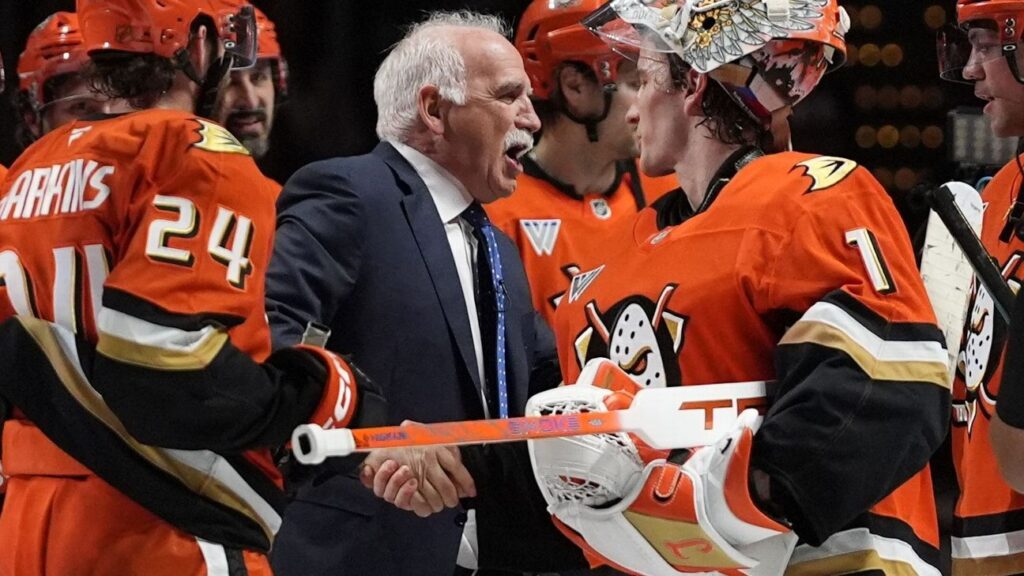 Anaheim Ducks head coach Joel Quenneville standing behind the bench during an NHL game