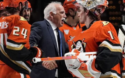Anaheim Ducks head coach Joel Quenneville standing behind the bench during an NHL game