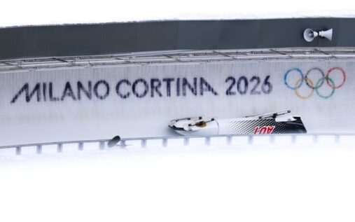 Medics attending to a bobsleigh driver on the ice track during the Winter Olympics