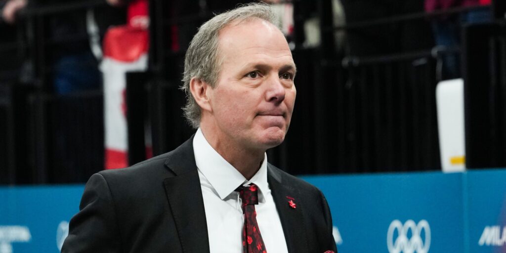 Jon Cooper looking pensive while standing behind the bench during an ice hockey match