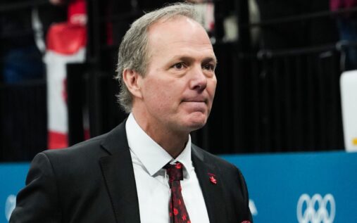 Jon Cooper looking pensive while standing behind the bench during an ice hockey match