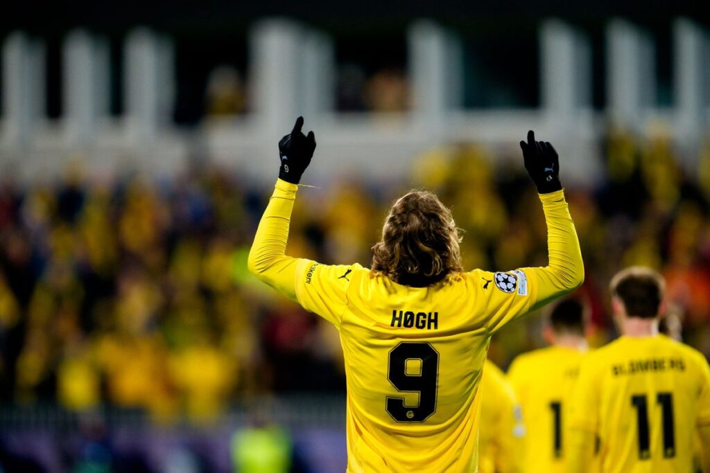 Players from Bodo/Glimt celebrating a goal during a European match under floodlights
