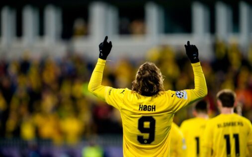 Players from Bodo/Glimt celebrating a goal during a European match under floodlights