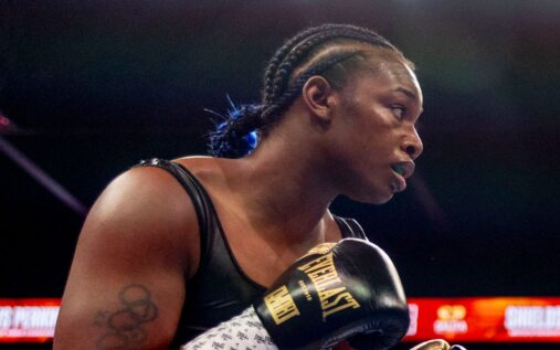 Claressa Shields celebrating in the ring with her championship belts
