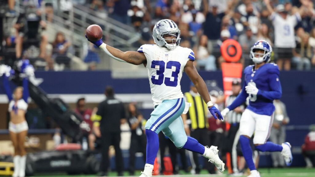 Javonte Williams running with the ball in a Dallas Cowboys uniform during an NFL game