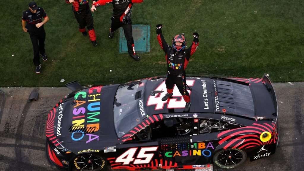 Tyler Reddick's 23XI Racing Toyota car crossing the finish line at the Daytona International Speedway