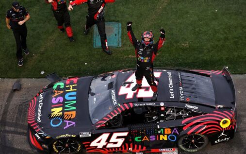 Tyler Reddick's 23XI Racing Toyota car crossing the finish line at the Daytona International Speedway