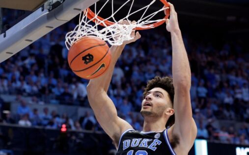 Duke players celebrating on the court after securing a victory against Michigan