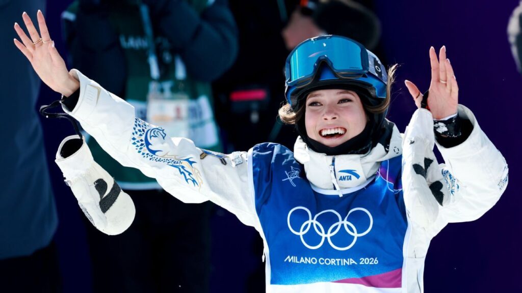 Eileen Gu celebrating her halfpipe victory with ski poles raised in Livigno