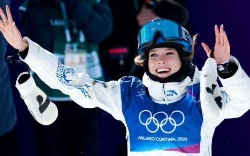 Eileen Gu celebrating her halfpipe victory with ski poles raised in Livigno