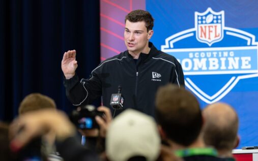 Fernando Mendoza speaking to the media at a podium during the NFL Scouting Combine in Indianapolis