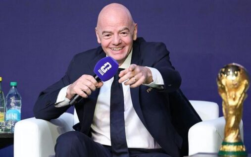 Gianni Infantino speaking at a podium during a Fifa congress wearing a dark suit and blue tie