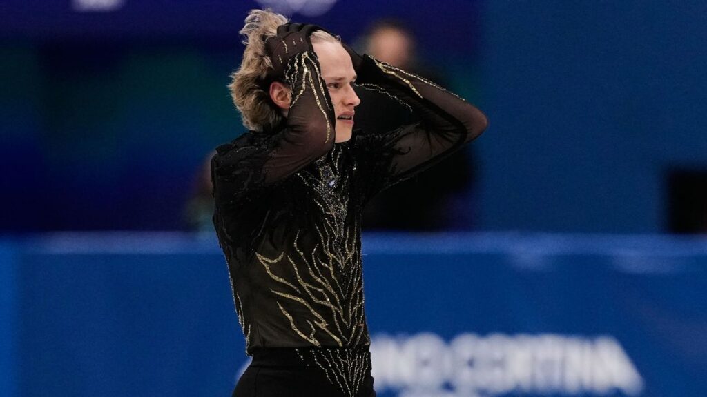 Ilia Malinin looks dejected with his head in his hands after a difficult free skate performance