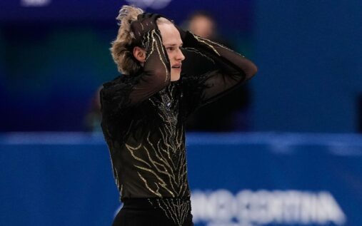 Ilia Malinin looks dejected with his head in his hands after a difficult free skate performance