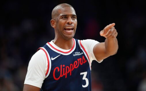 Chris Paul dribbling the basketball and directing play while wearing a Los Angeles Clippers jersey