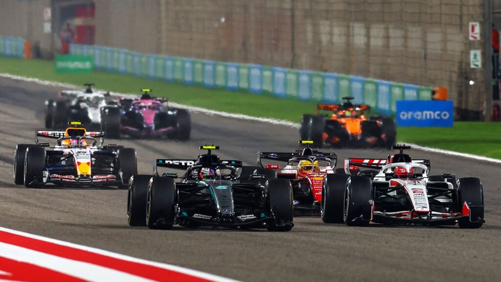 George Russell wearing a Mercedes cap speaking to media in the paddock during F1 pre-season testing