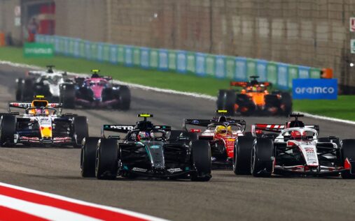 George Russell wearing a Mercedes cap speaking to media in the paddock during F1 pre-season testing