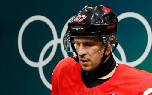 Sidney Crosby appearing in pain on the team bench while receiving medical attention during the Olympic quarter-final against Czechia