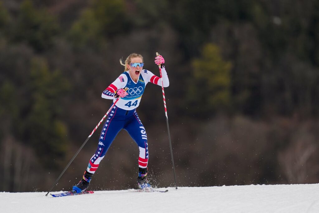 Female cross-country skiers competing on a snowy course in Val di Fiemme during a classic style race