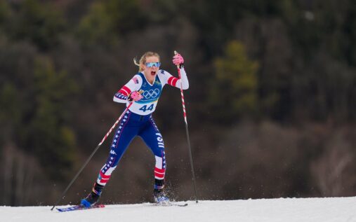 Female cross-country skiers competing on a snowy course in Val di Fiemme during a classic style race