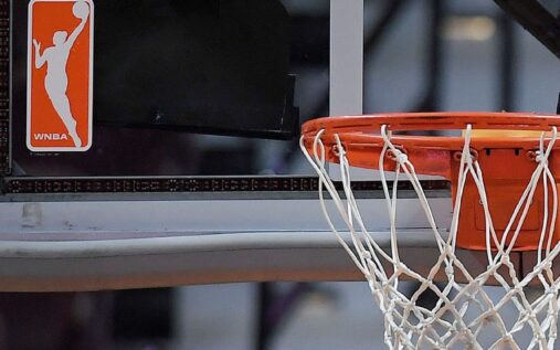 WNBA players huddled on the court during a game discussing strategy