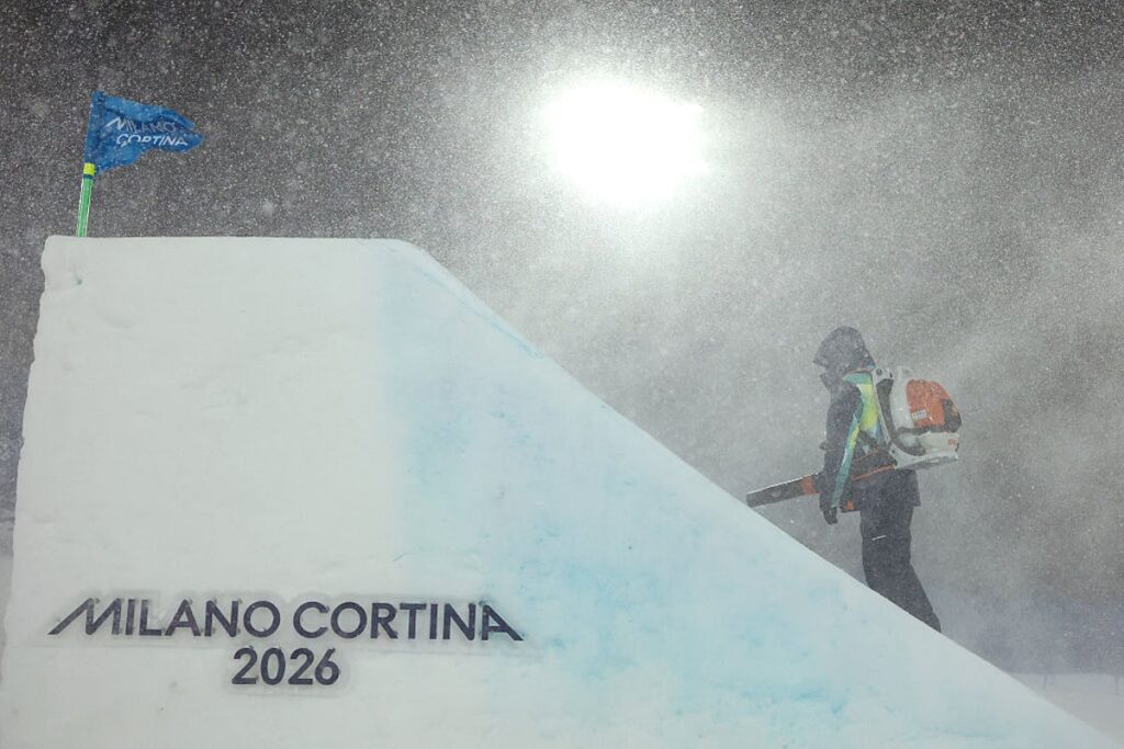 Ground staff clearing heavy snow from a ski slope during a blizzard at the Winter Olympics in Livigno