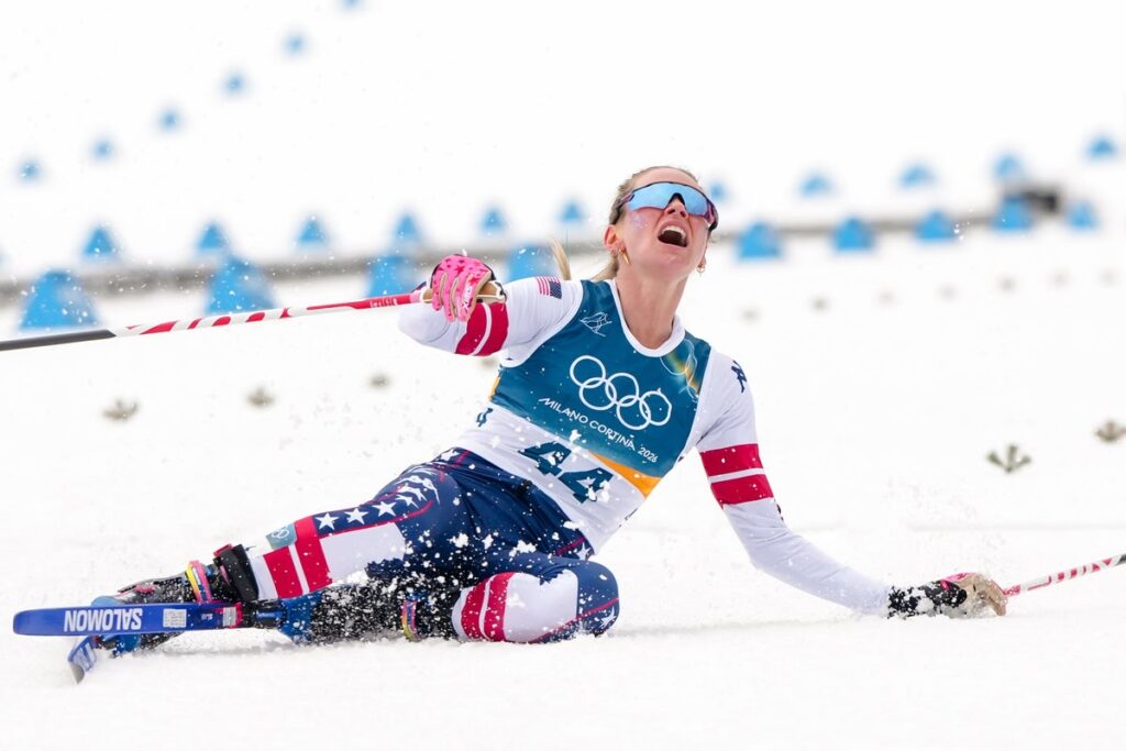 Jessie Diggins lying on the snow in exhaustion and pain after finishing the 10km freestyle race at the Winter Olympics