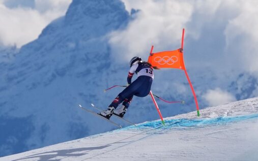 Lindsey Vonn speaking to camera from a hospital bed in Italy with a visible bruise under her eye