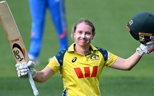 Alyssa Healy raising her bat to the crowd to celebrate a century for Australia women