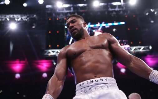 Anthony Joshua walking to the boxing ring alongside promoter Eddie Hearn