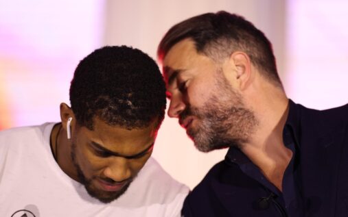 Eddie Hearn standing alongside British heavyweight boxer Anthony Joshua during a ring walk
