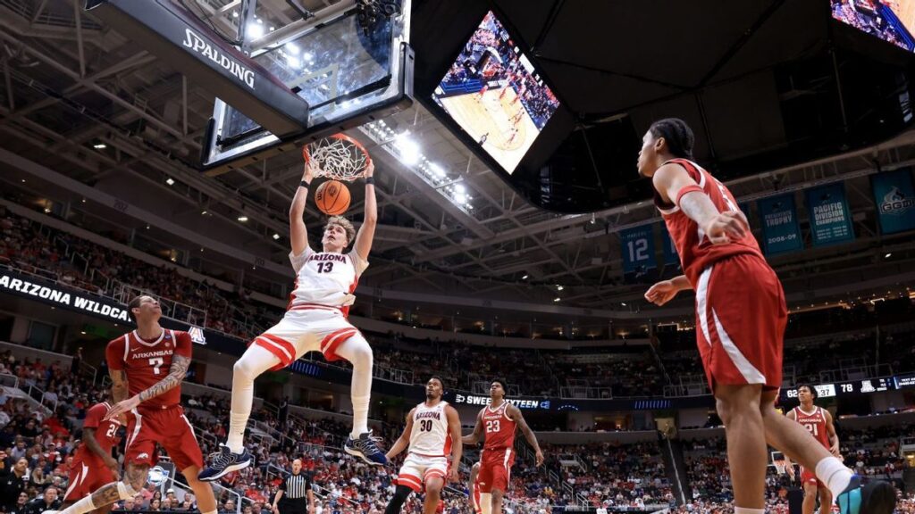 Arizona Wildcats players celebrating their NCAA Sweet 16 victory against the Arkansas Razorbacks on the basketball court.