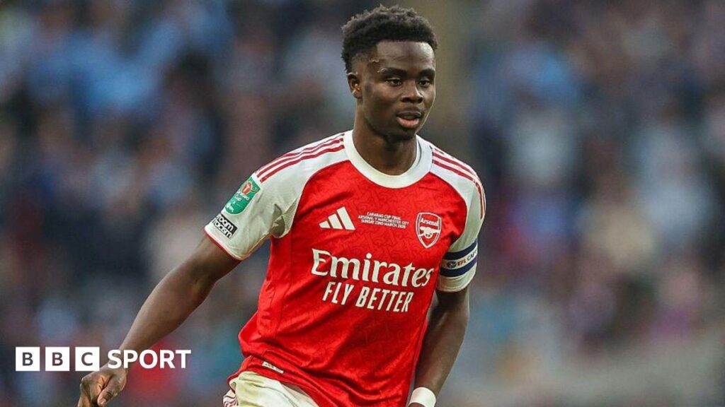 Bukayo Saka looking dejected on the pitch during an Arsenal match