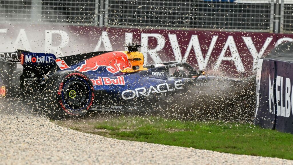 Max Verstappen walking away from his damaged Red Bull car in the gravel trap at the Australian Grand Prix