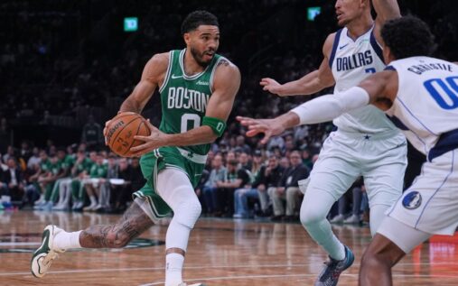 Jayson Tatum driving to the basket in a Celtics jersey during his return game against the Dallas Mavericks