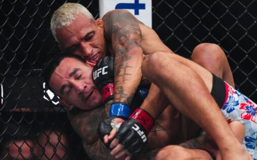 Charles Oliveira grappling against Max Holloway in the octagon during their BMF title fight at UFC 326 in Las Vegas