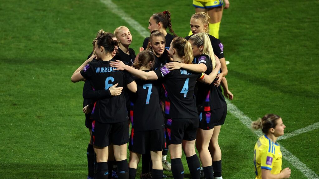 England women's players consoling and embracing Ukraine players after their World Cup qualifying match in Turkey.