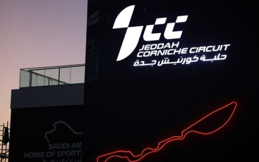 Formula 1 cars racing under floodlights at the Bahrain International Circuit during a Grand Prix