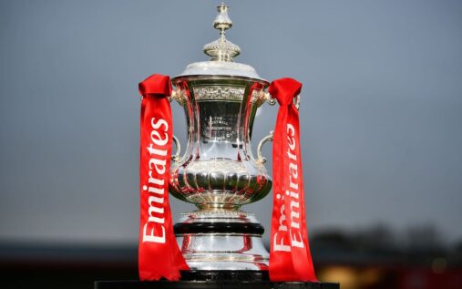 The Emirates FA Cup trophy displayed on a plinth at Wembley Stadium
