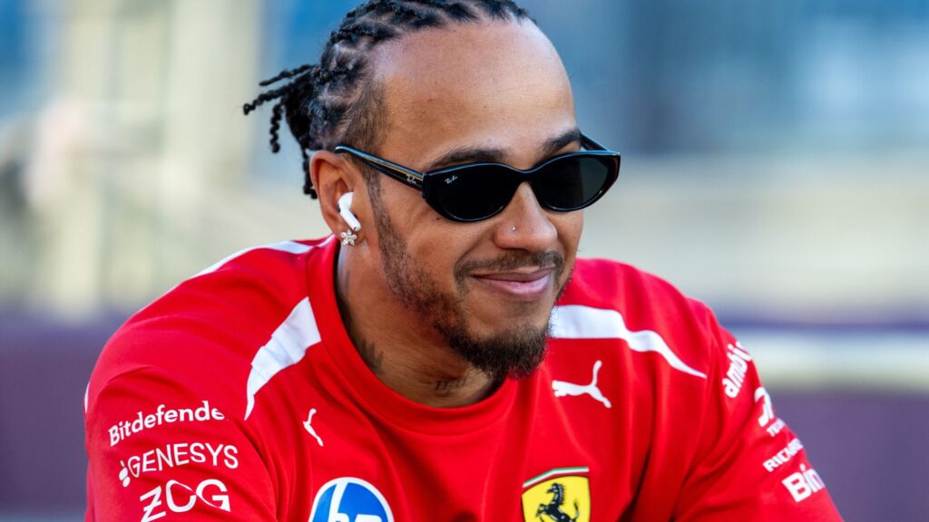 Ferrari team principal Frederic Vasseur and driver Lewis Hamilton walking together in the Formula 1 paddock