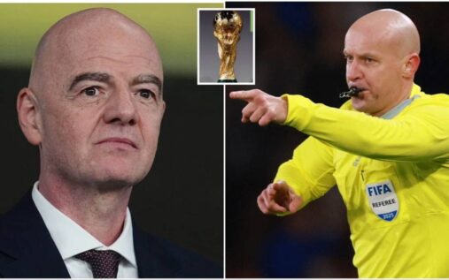 A football referee signalling towards the pitch during an international match