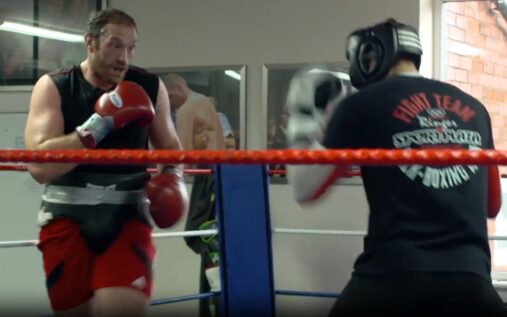 Rico Verhoeven and Tyson Fury wearing headguards during a sparring session in a boxing ring