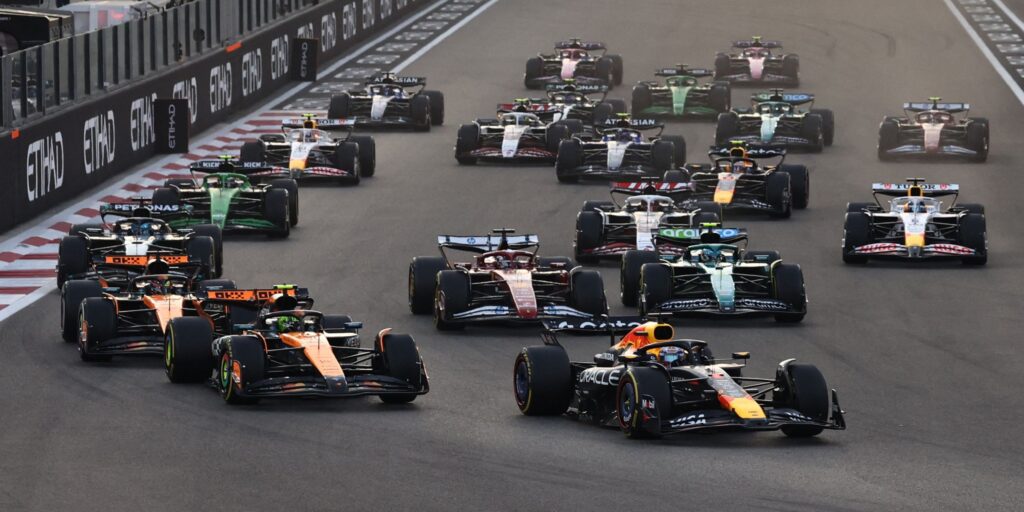 Formula 1 cars lined up on the grid ahead of a Middle Eastern Grand Prix under floodlights