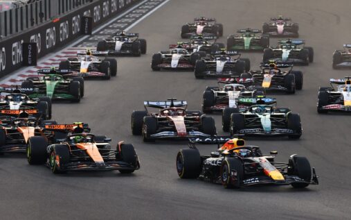 Formula 1 cars lined up on the grid ahead of a Middle Eastern Grand Prix under floodlights