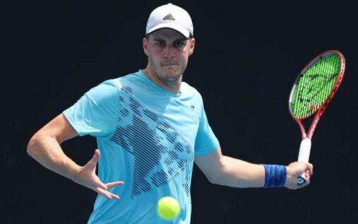 Henry Patten hitting a forehand volley during a doubles match on a hard court