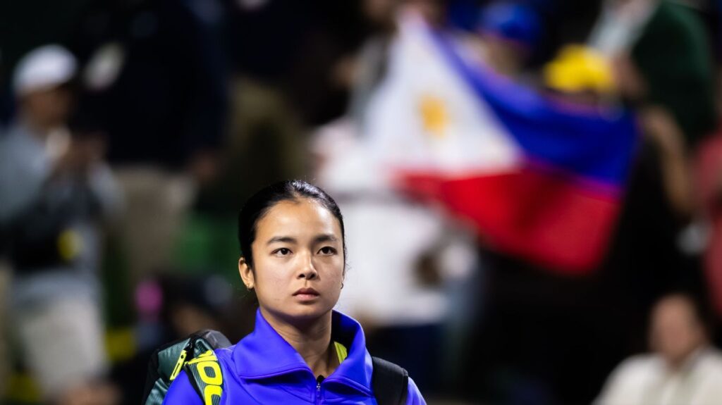 Alex Eala celebrating a victory on a hard court tennis stadium at Indian Wells surrounded by fans