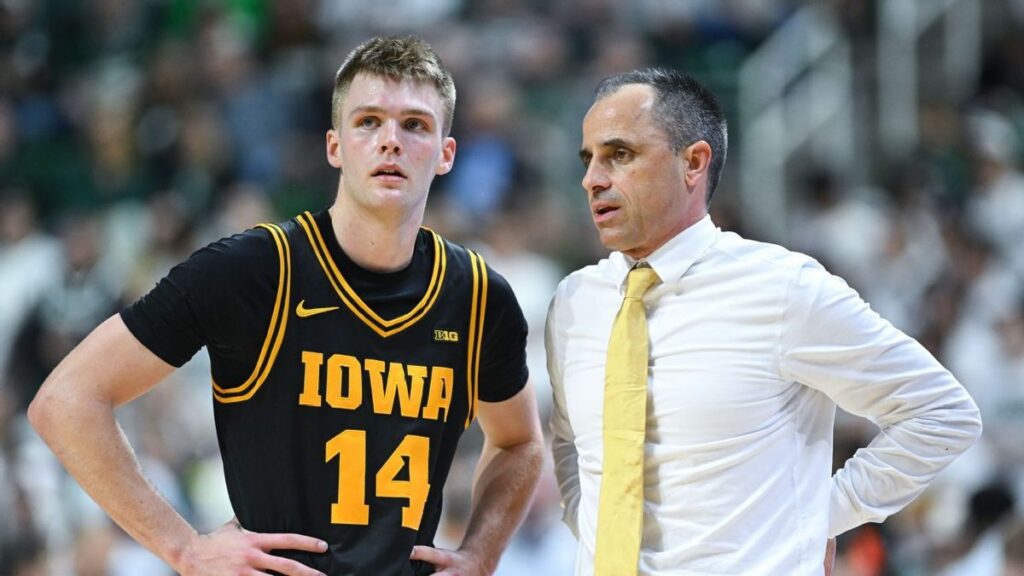 Iowa Hawkeyes coach Ben McCollum and guard Bennett Stirtz celebrating on the basketball court