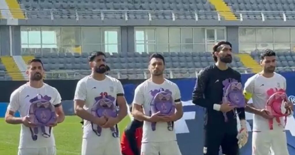 Iran national football team players holding backpacks during the national anthem before a match