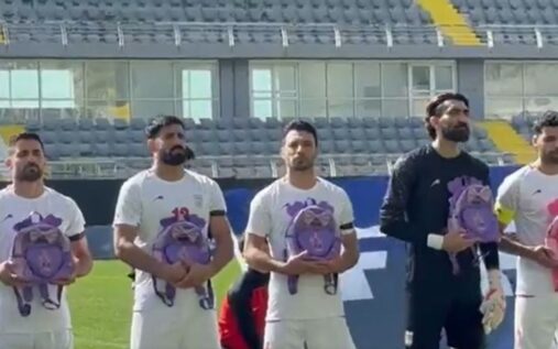 Iran national football team players holding backpacks during the national anthem before a match
